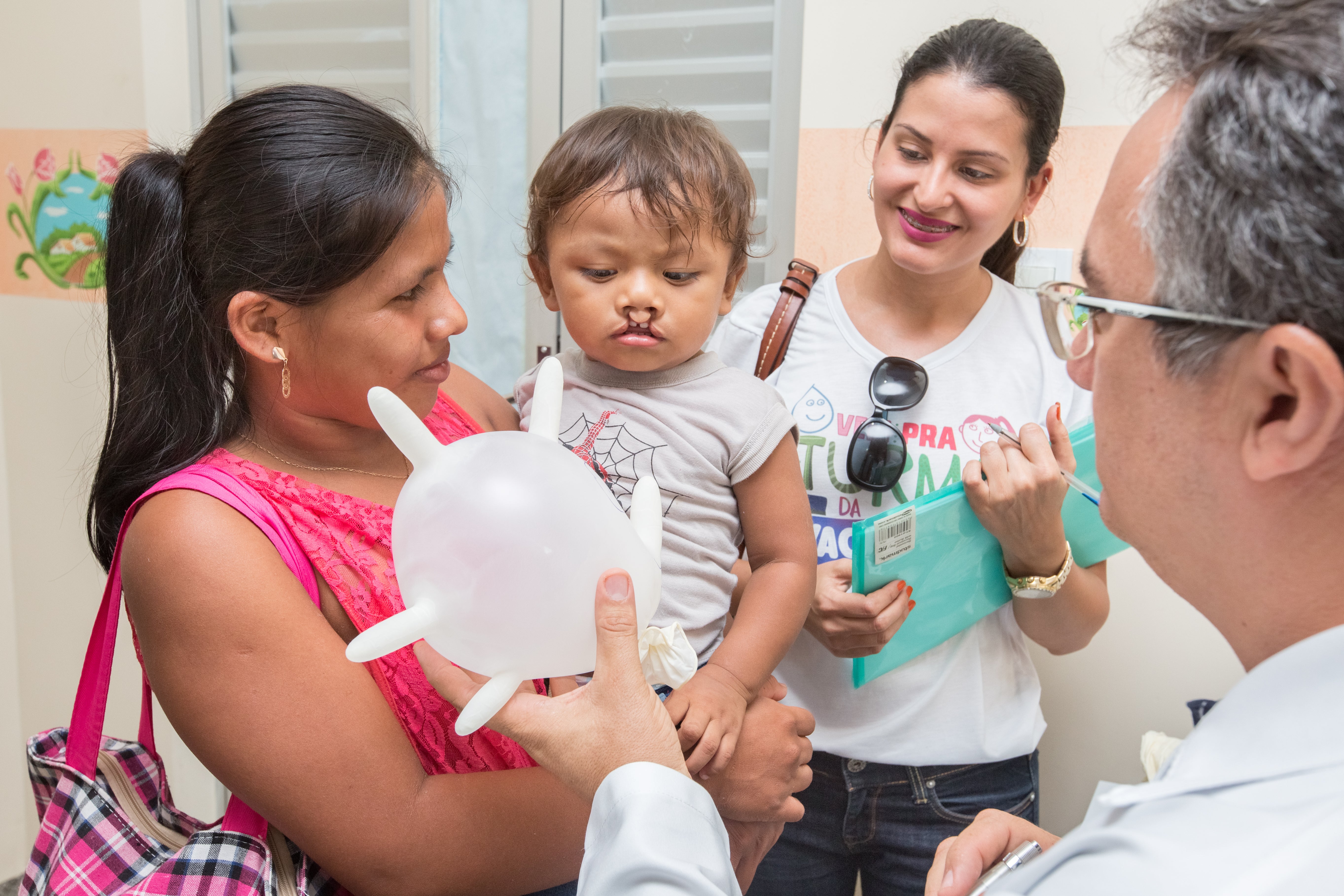 Dr. Theomário Melo blowing up a glove balloon for Kalebe