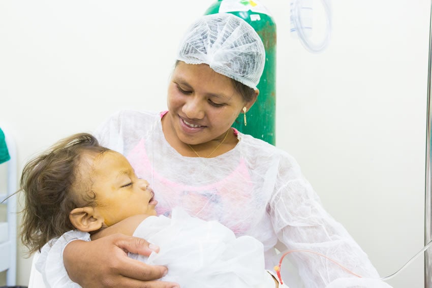 Jeane smiling and holding Kalebe after cleft surgery