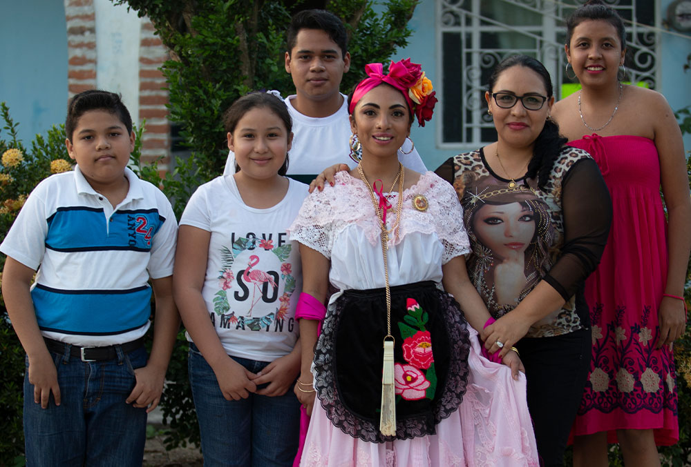 Adahara, vestido com roupas tradicionais mexicanas, posa com um grupo de vizinhos depois de receber tratamento de fenda