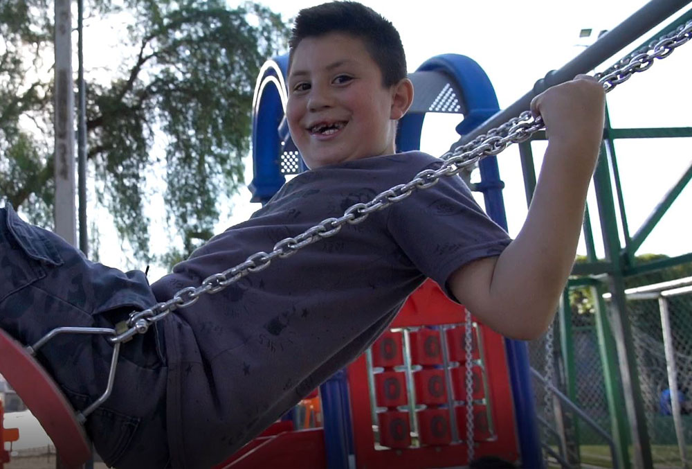 Amaro smiling on the swing