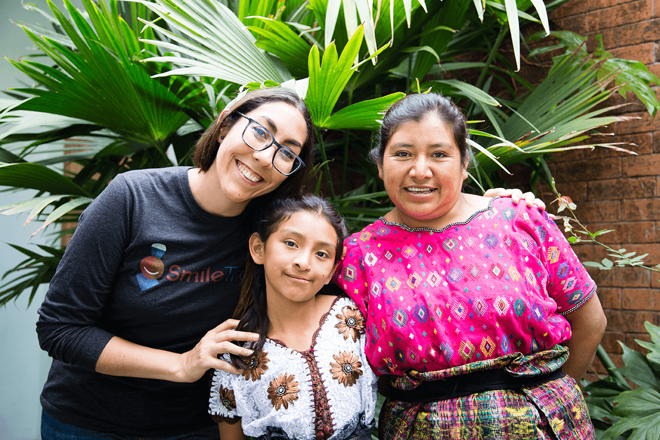 Andrea smiling with a patient and her mother