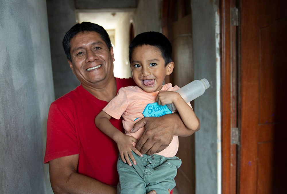 Anghelo smiling in his fathers arms