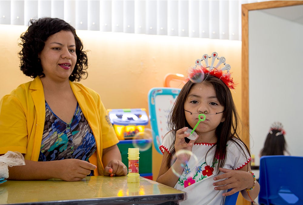 Barbara sopra bolhas durante a terapia de fala patrocinada pela Smile Train.