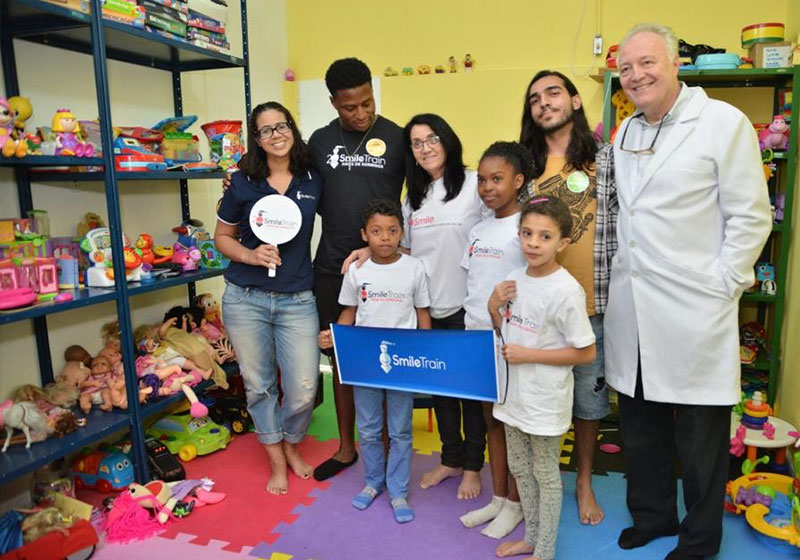 Camila sorri com parceiros e pacientes da Smile Train