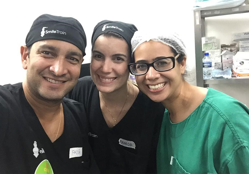 Camila smiling with partners in scrubs
