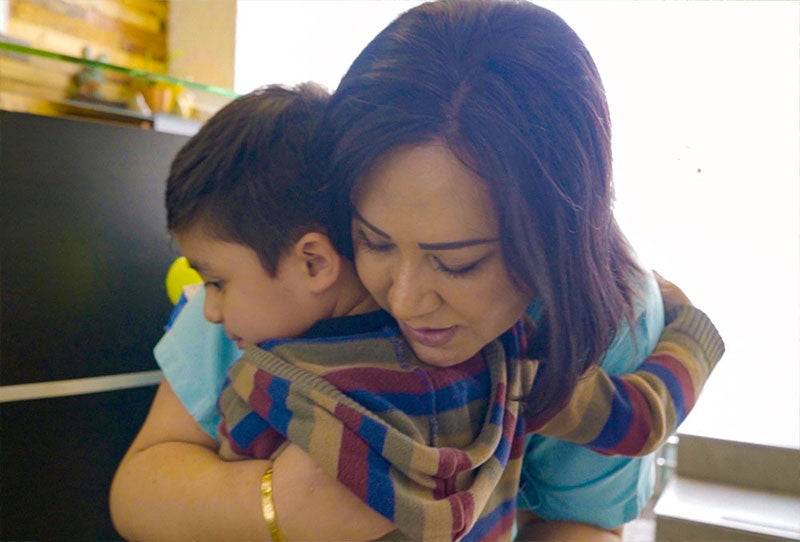 Dr. Karina Cabal hugging Damián at Centro SUMA, where she is the CEO