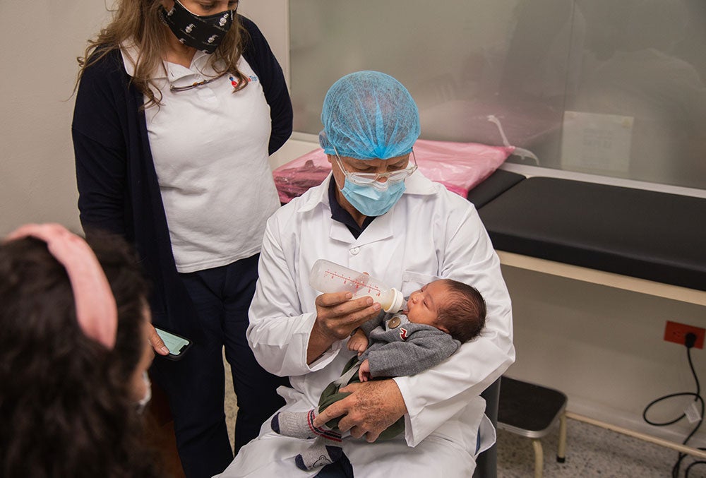 A doctor bottle feeds a patient at FISULAB