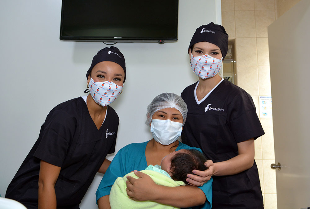 Elle e Yely com um paciente e sua mãe logo após a cirurgia de fissura labiopalatina patrocinada pela Smile Train
