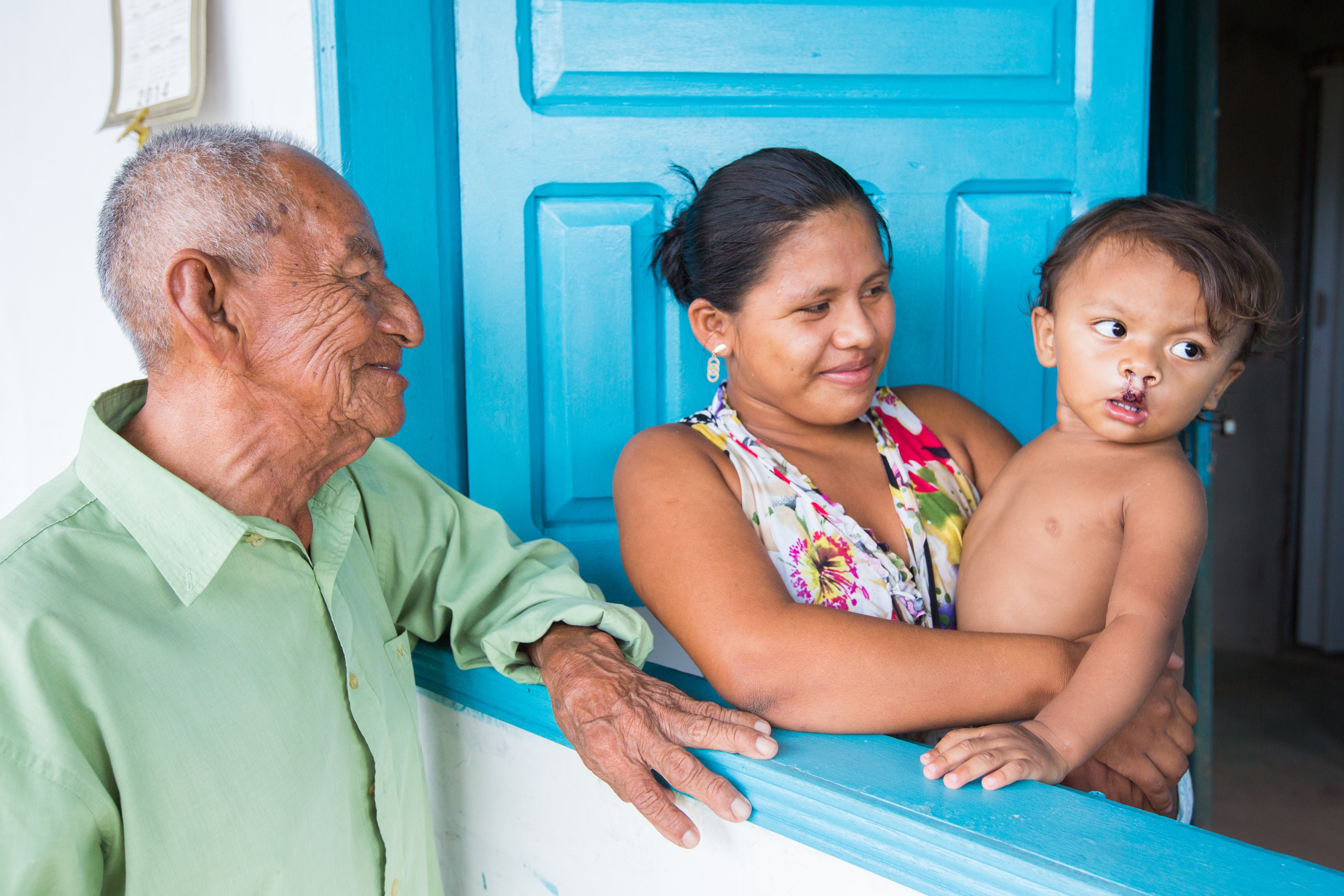 Jeane smiling with Kalebe and his great-grandfather