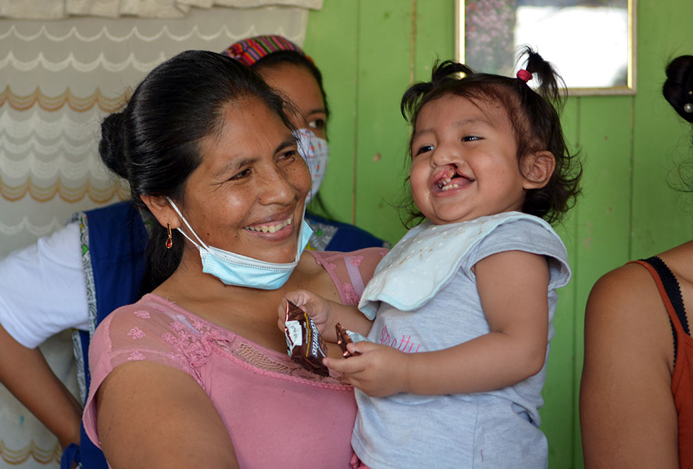 Smile Train patient Jenifer smiles in her mother's arms