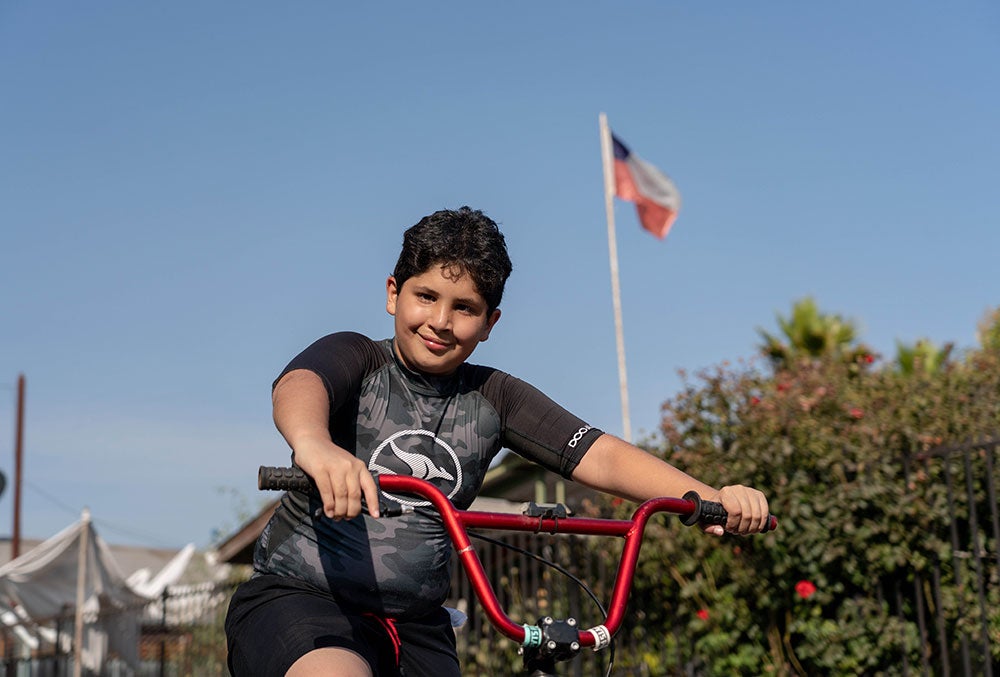 Juan smiling and riding a bike