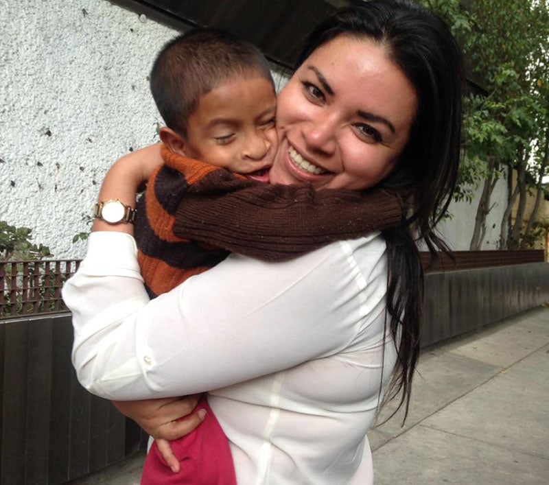 Karla sorrindo e segurando um paciente