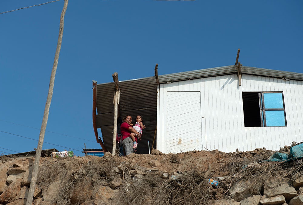 Cinthya e Kristhell olham para baixo de sua casa