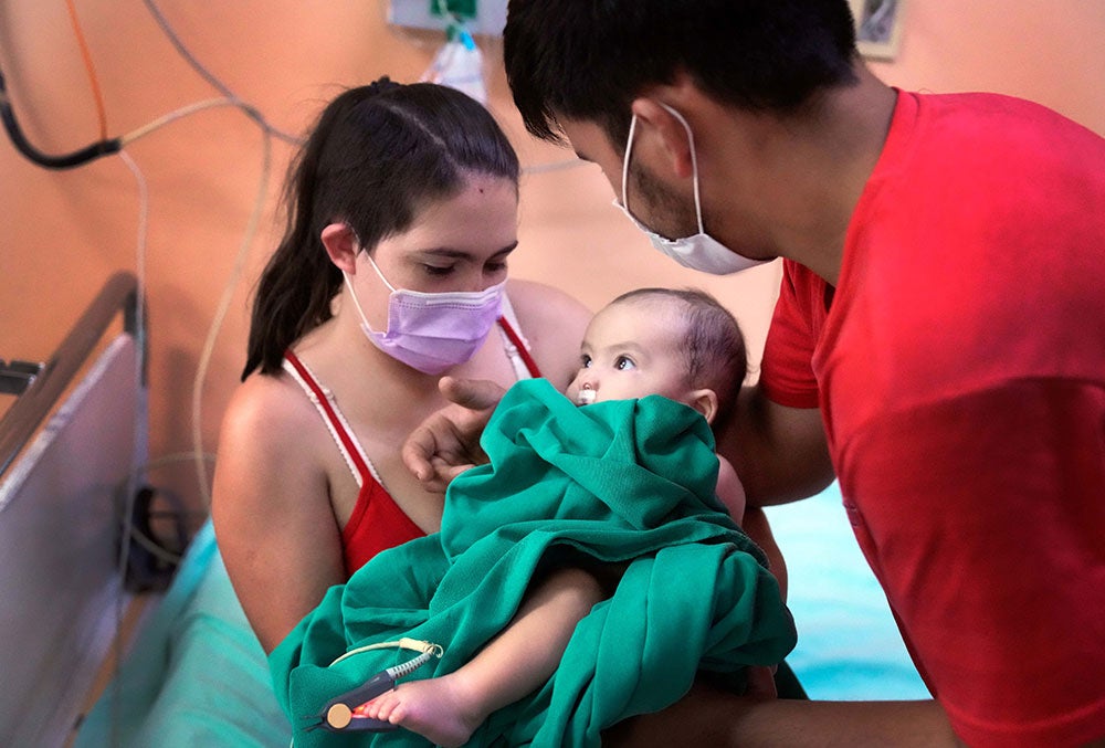 Rocio e Edgar segurando seu filho, Maxi