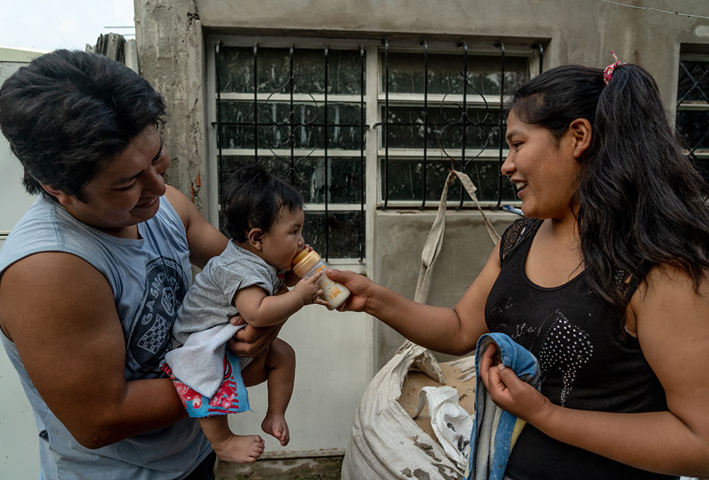 Miguel's parents feeding him after cleft surgery