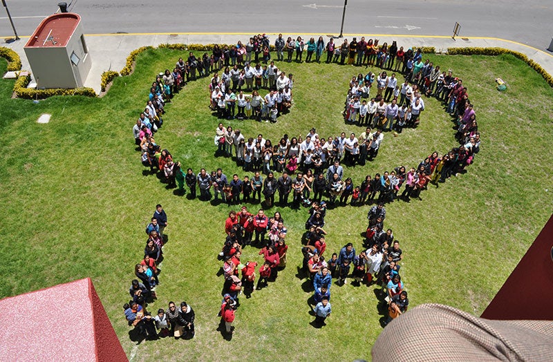 Os parceiros de trem do sorriso formam um sorriso gigante e "lph" no dia nacional de fissura e palatina no México