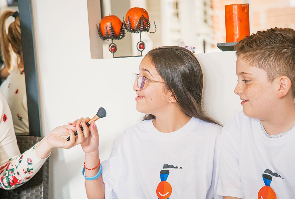 Diana handing Valery one of the make-up brushes she won