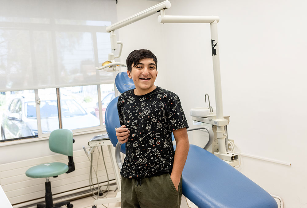 Vicente sorrindo na frente da cadeira do dentista