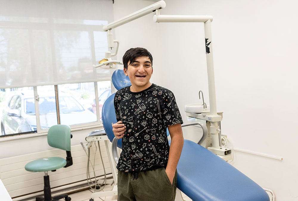 Vicente smiling in front of dentists chair