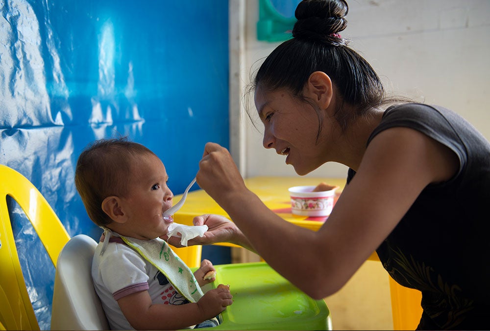 Zindia feeding Joseyur from a spoon