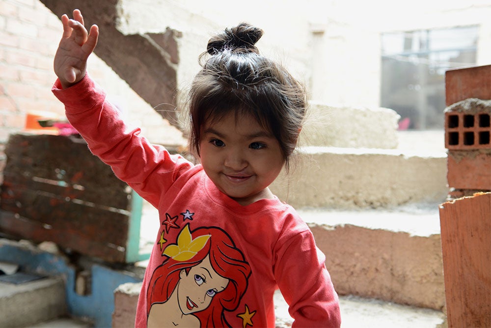 Shaymi smiling and raising her hand after cleft surgery