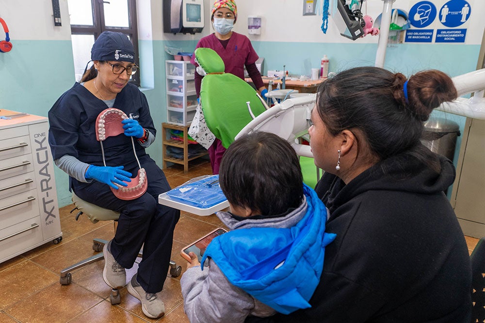 Brosly demonstrating oral hygiene with a large model of a mouth