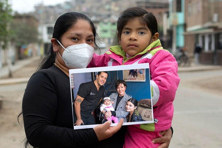 Luz and Mia holding a picture of themselves with Kylie and Kris Jenner 