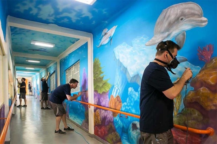 Jason Hulfish painting a mural