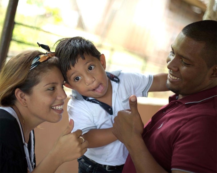 Elifeleth smiling with his parents