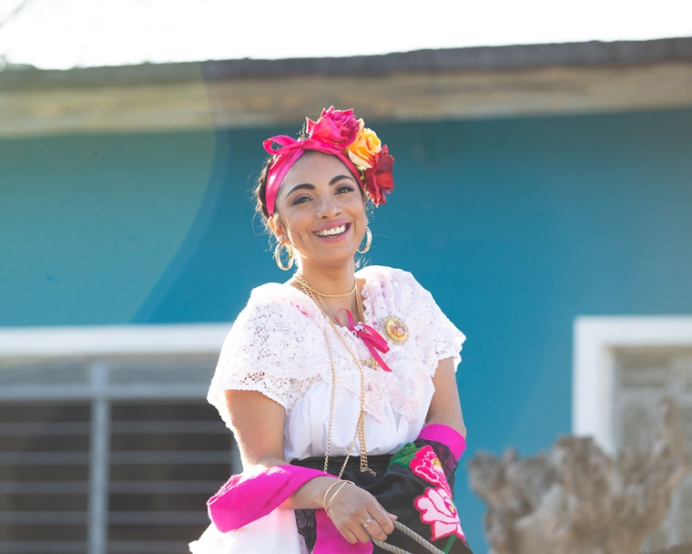 Adahara sorrindo enquanto vestia roupas tradicionais mexicanas e montando um cavalo.