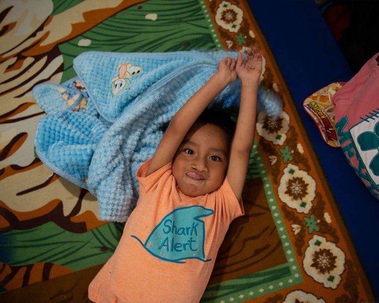 Anghelo laying on blanket after cleft surgery