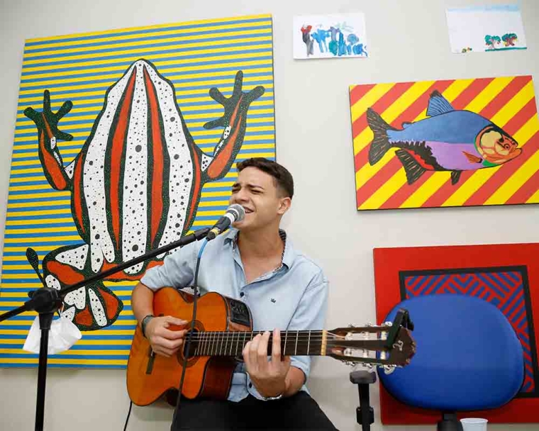 Artista Renan Andrade canta música com violão