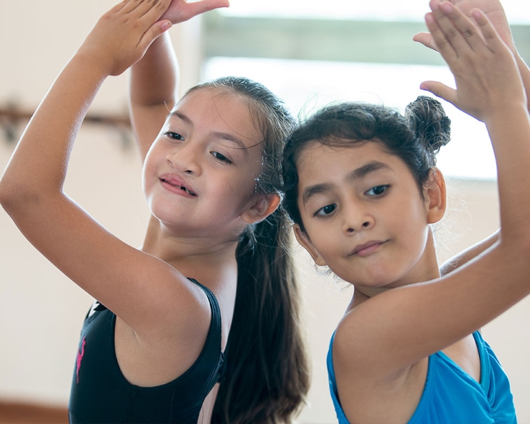 Aquetzaly smiling with her classmate in ballet class