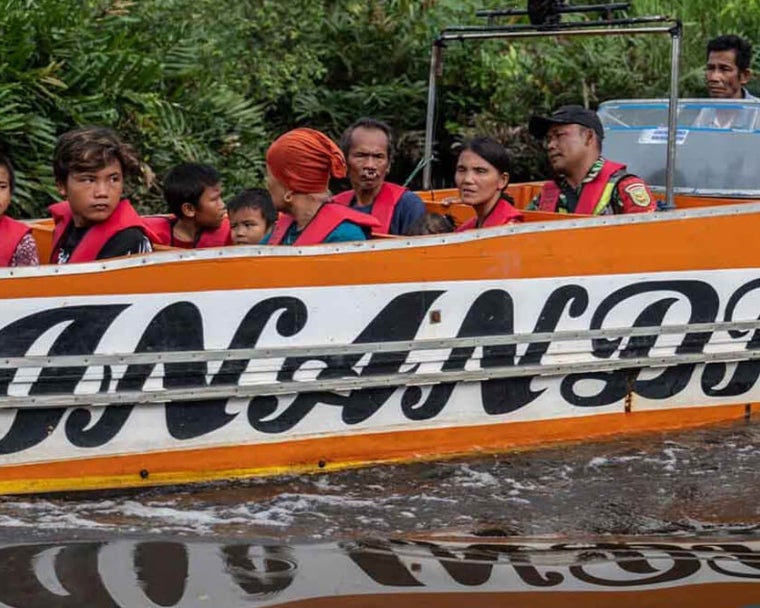 Alim e Rajib indo de barco com sua família para o centro de tratamento antes da cirurgia de fissura labiopalatina